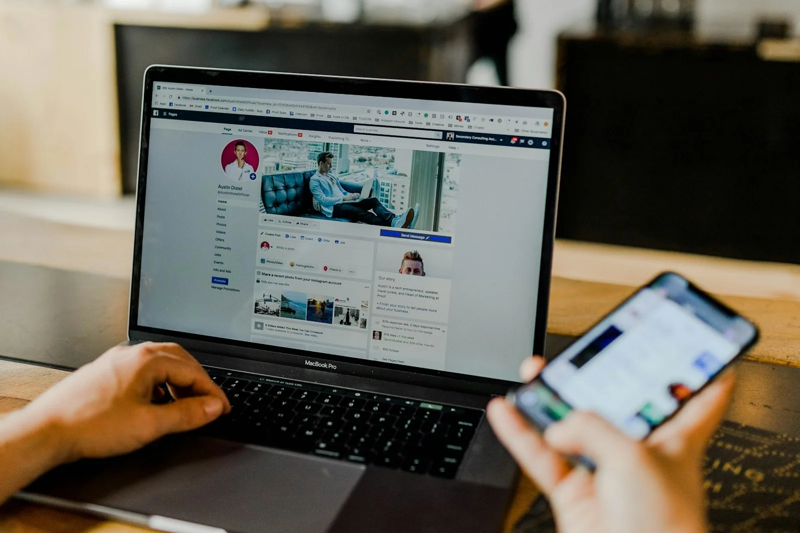 Person managing social media content on a laptop and smartphone