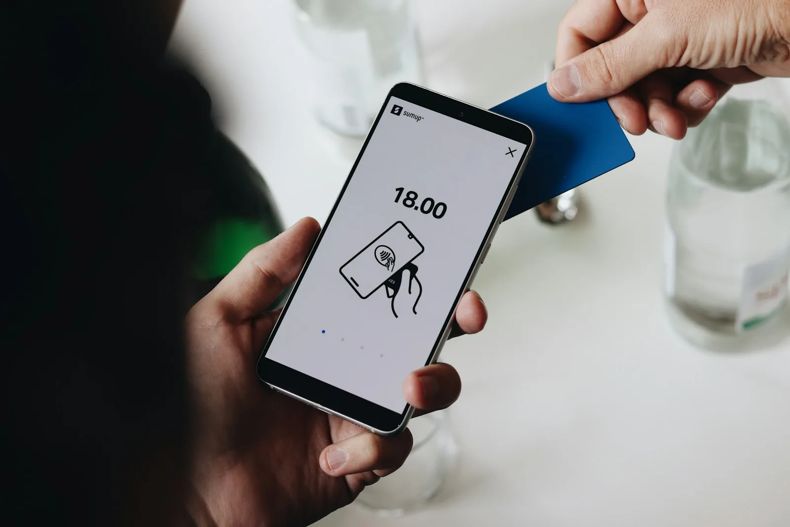 Person holding a smartphone to compare AI agent subscription pricing
